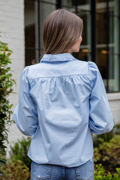 Woman wearing a light blue denim jacket outdoors