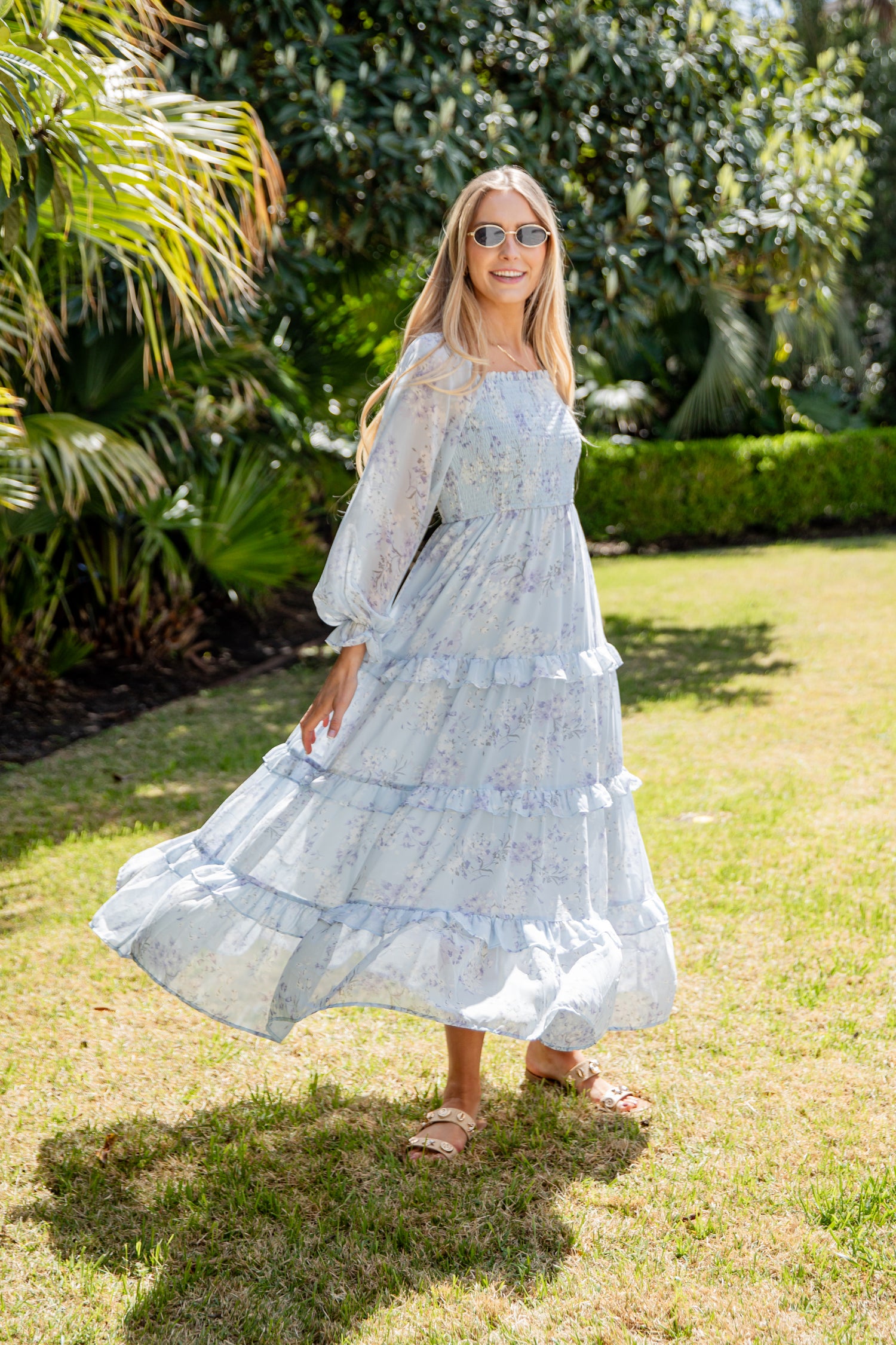 Woman in a light blue dress standing in a garden