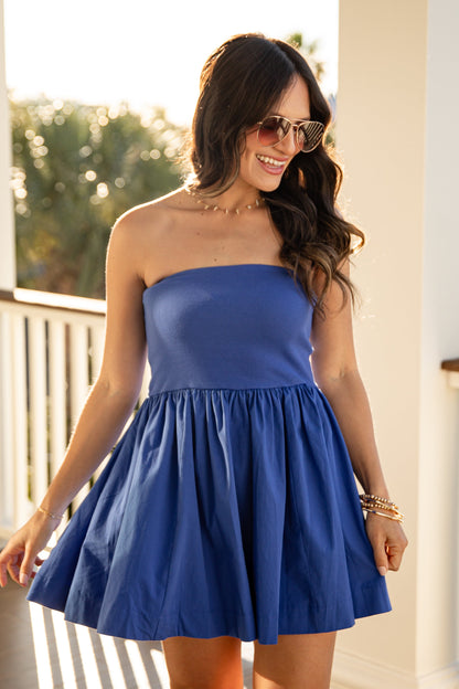 Woman wearing a blue dress on a balcony