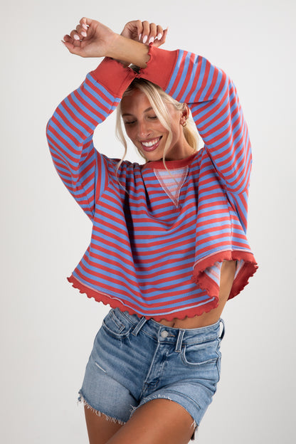 Woman wearing a red and blue striped shirt with denim shorts on a white background
