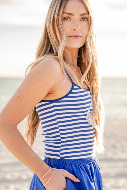 Woman wearing a blue and white striped tank top on a beach