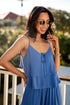 Woman wearing a blue dress with sunglasses outdoors