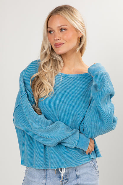 Woman wearing a blue sweater against a plain background