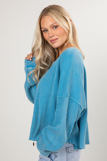 Woman wearing a blue sweater against a white background