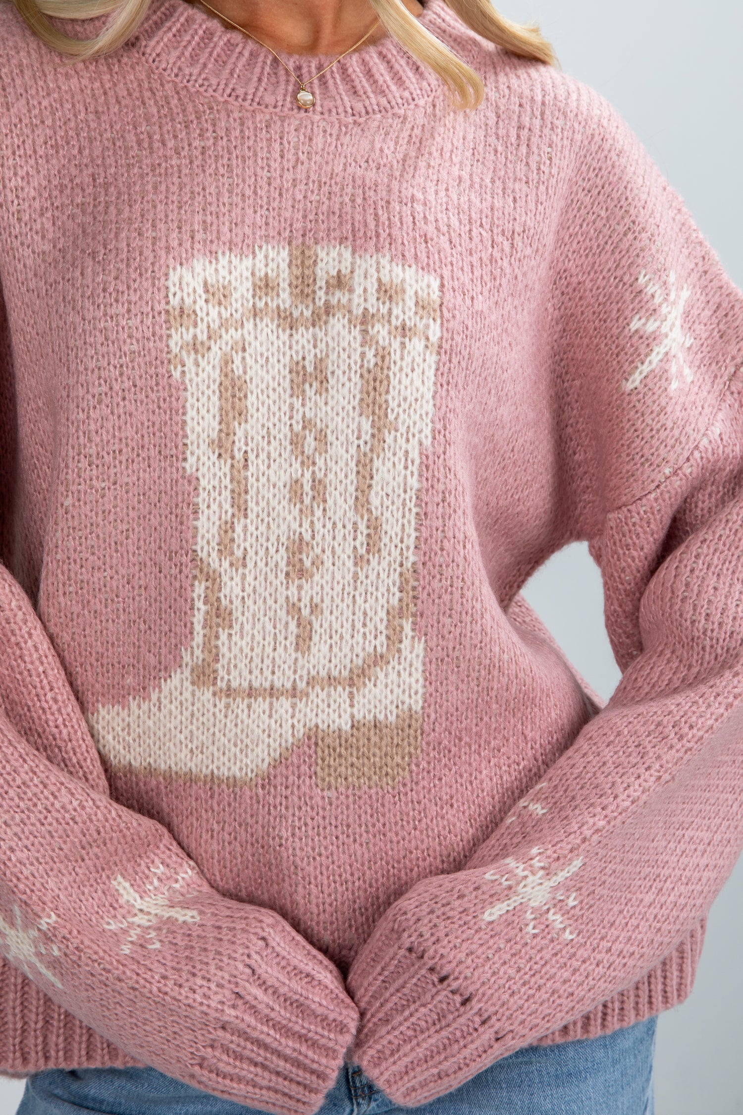 Pink sweater with a cat design on a light gray background