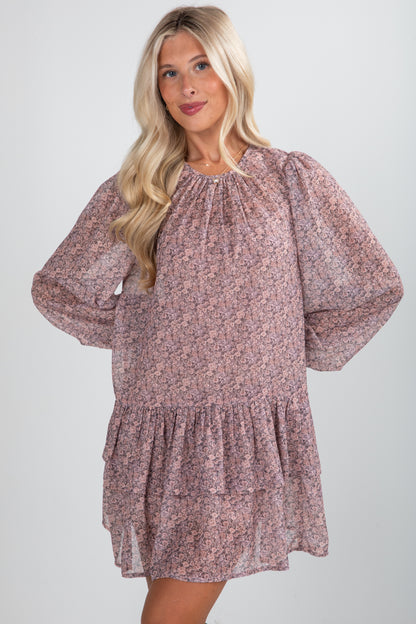 Woman wearing a floral dress with balloon sleeves on a plain background