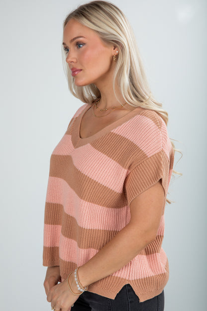 Woman wearing a striped sweater with a neutral background