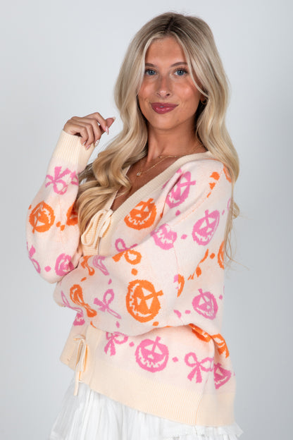 Woman wearing a colorful patterned cardigan on a plain background