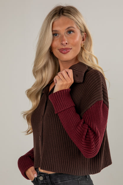 Woman wearing a brown and burgundy sweater vest against a plain background