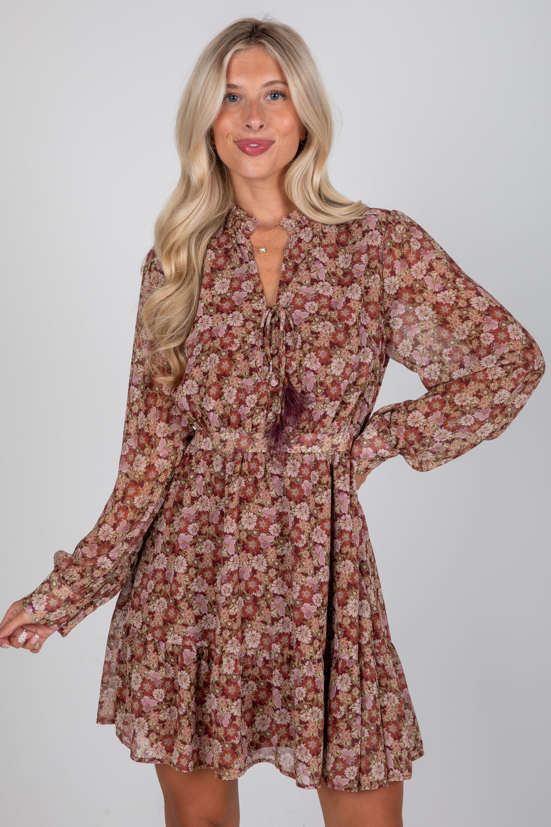 Woman wearing a floral dress against a plain background