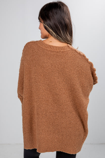 Person wearing a brown sweater from behind on a white background