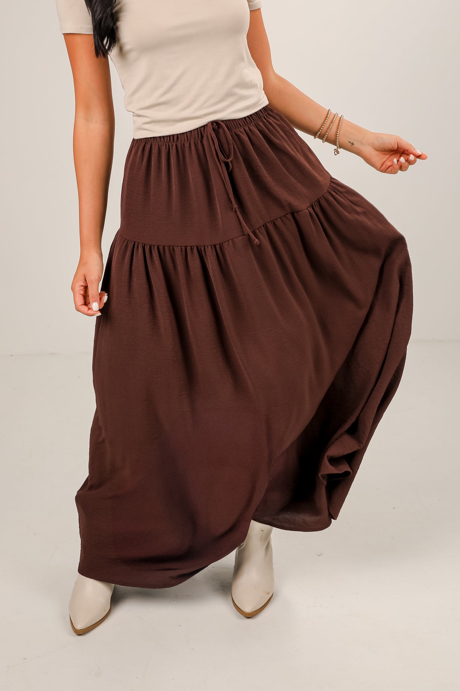 Brown maxi skirt worn by a person on a plain background
