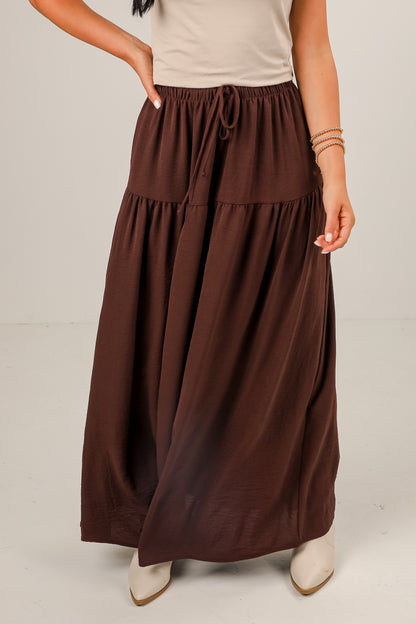 Brown maxi skirt worn by a person on a plain background