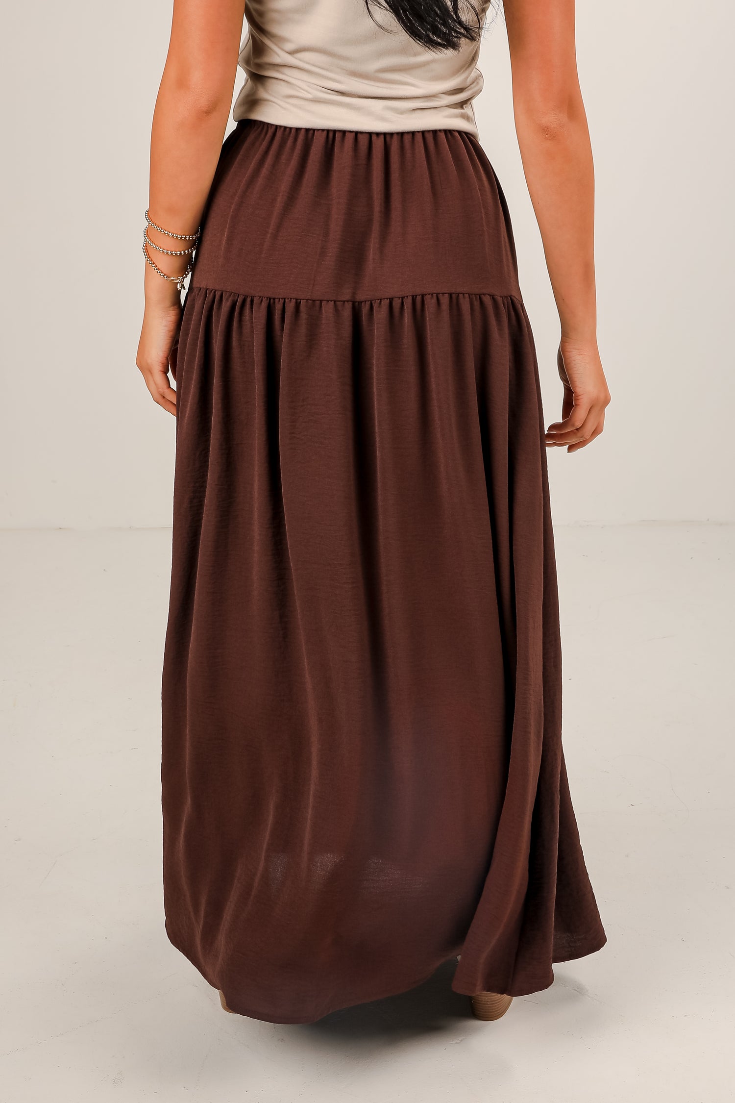 Brown maxi skirt worn by a person on a plain background