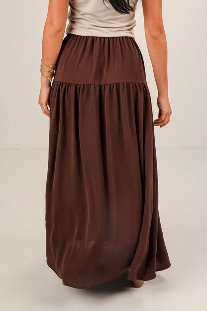 Brown maxi skirt worn by a person on a plain background
