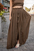Person wearing a brown outfit with wide-leg pants on a city street.