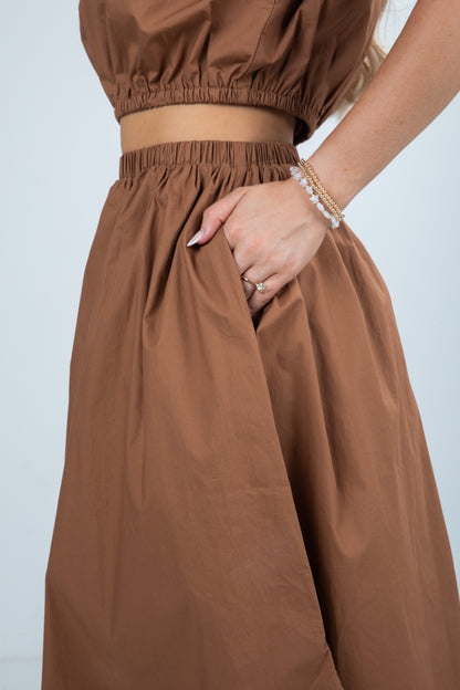 Brown outfit with a top and wide-leg pants on a plain background