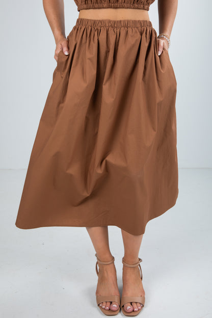 Brown skirt worn by a person on a white background