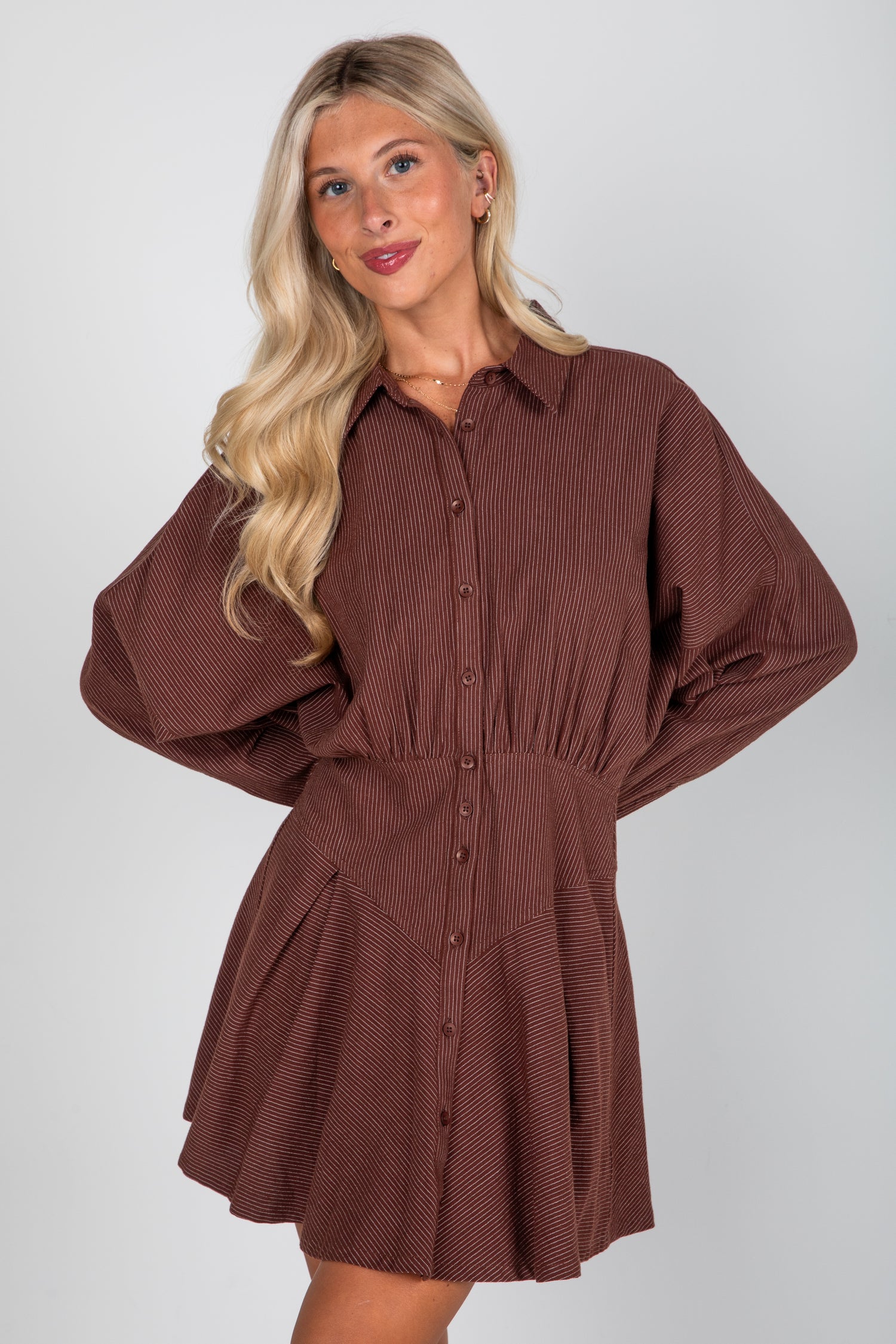 Woman wearing a brown dress against a white background