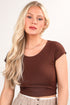 Woman wearing a brown top with a plain background