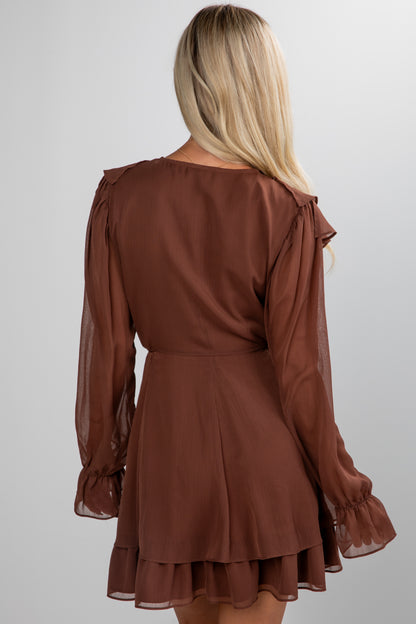 Brown dress with sheer sleeves worn by a person on a white background