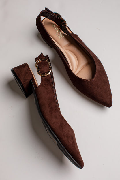 A pair of dark brown suede slingback flats with pointed toes and gold-tone buckle details, displayed on a light gray background.