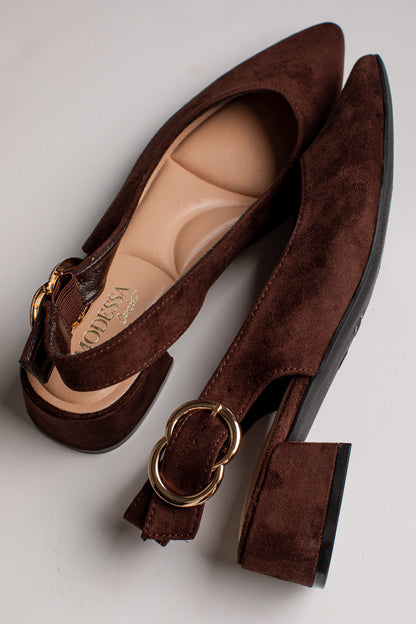 A pair of dark brown suede block-heel pumps with gold-tone ring hardware and ankle straps, displayed on a light gray background.