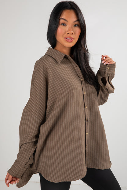 Woman wearing a brown ribbed shirt against a white background