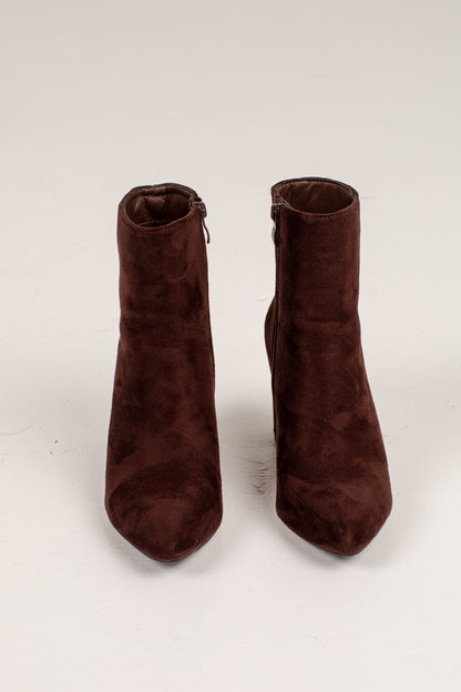 A pair of dark brown suede ankle boots with pointed toes and side zippers, photographed against a plain off-white background.