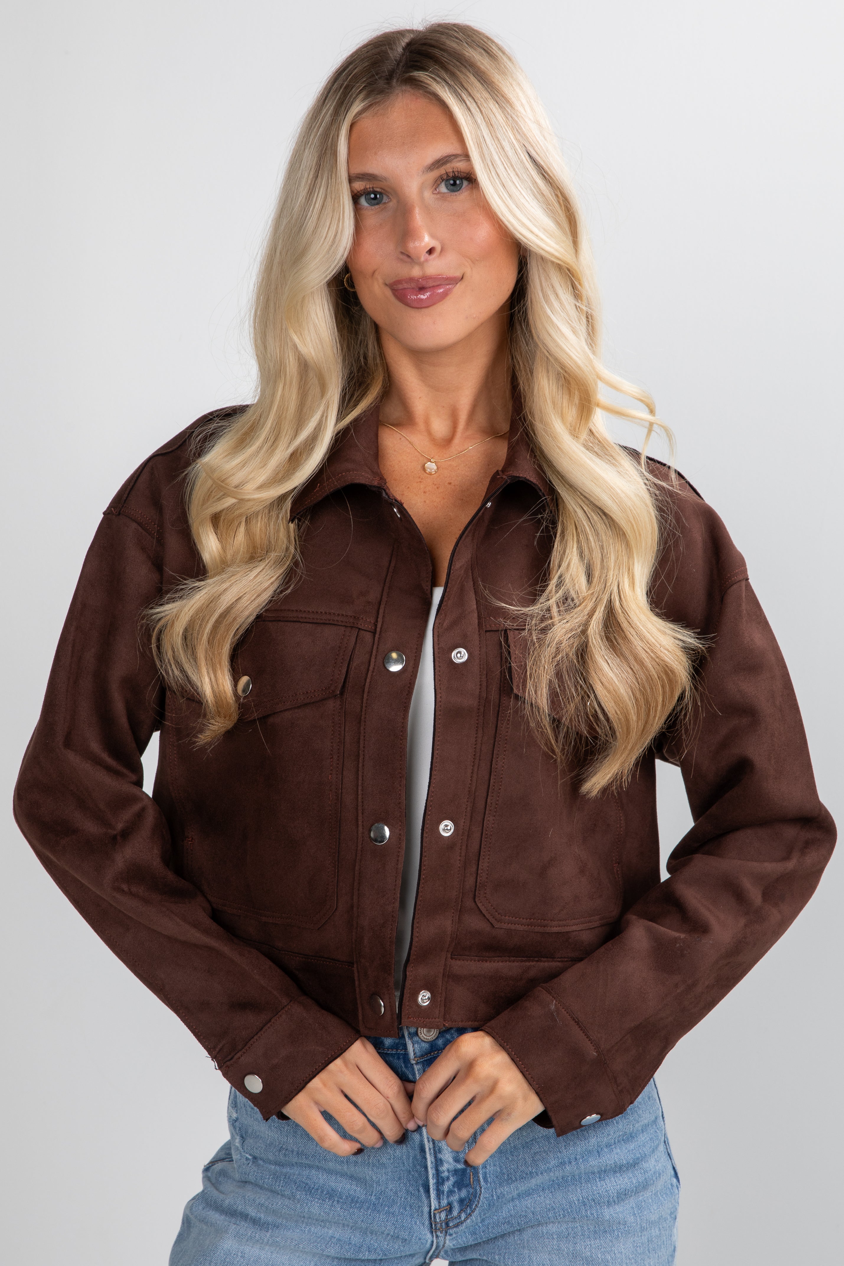 Woman wearing a brown jacket with a plain background