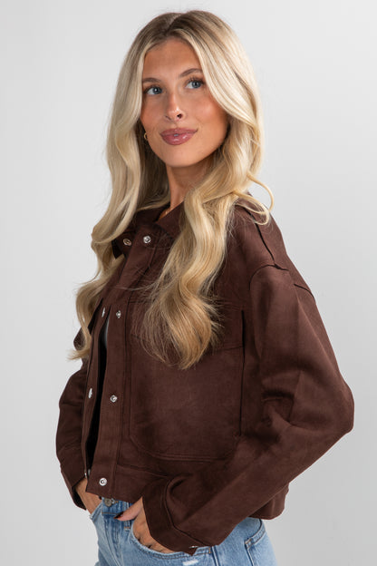 Woman wearing a brown jacket on a plain background