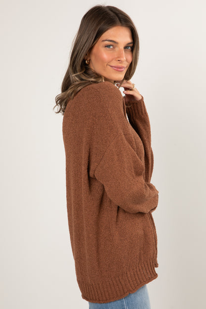 Woman wearing a brown sweater against a white background