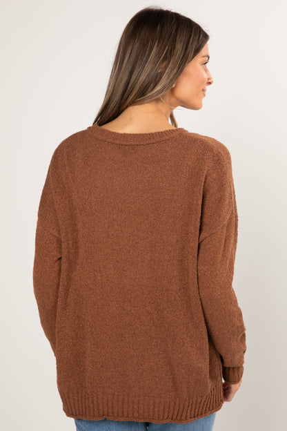 Woman wearing a brown sweater against a white background