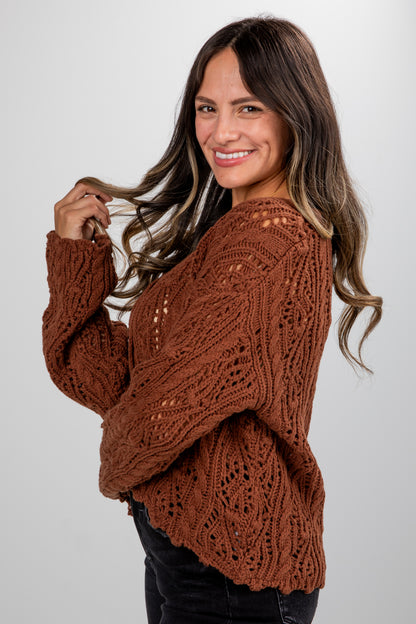 Woman wearing a brown knitted sweater against a white background