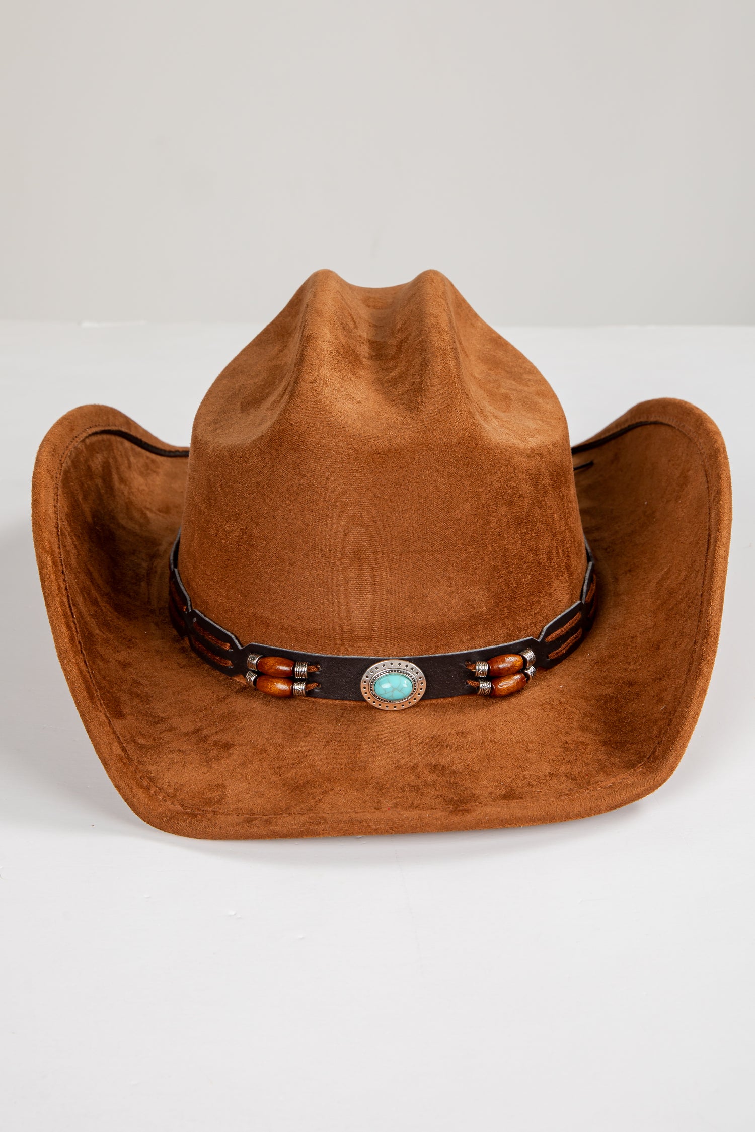 Brown cowboy hat with a decorative band on a white background