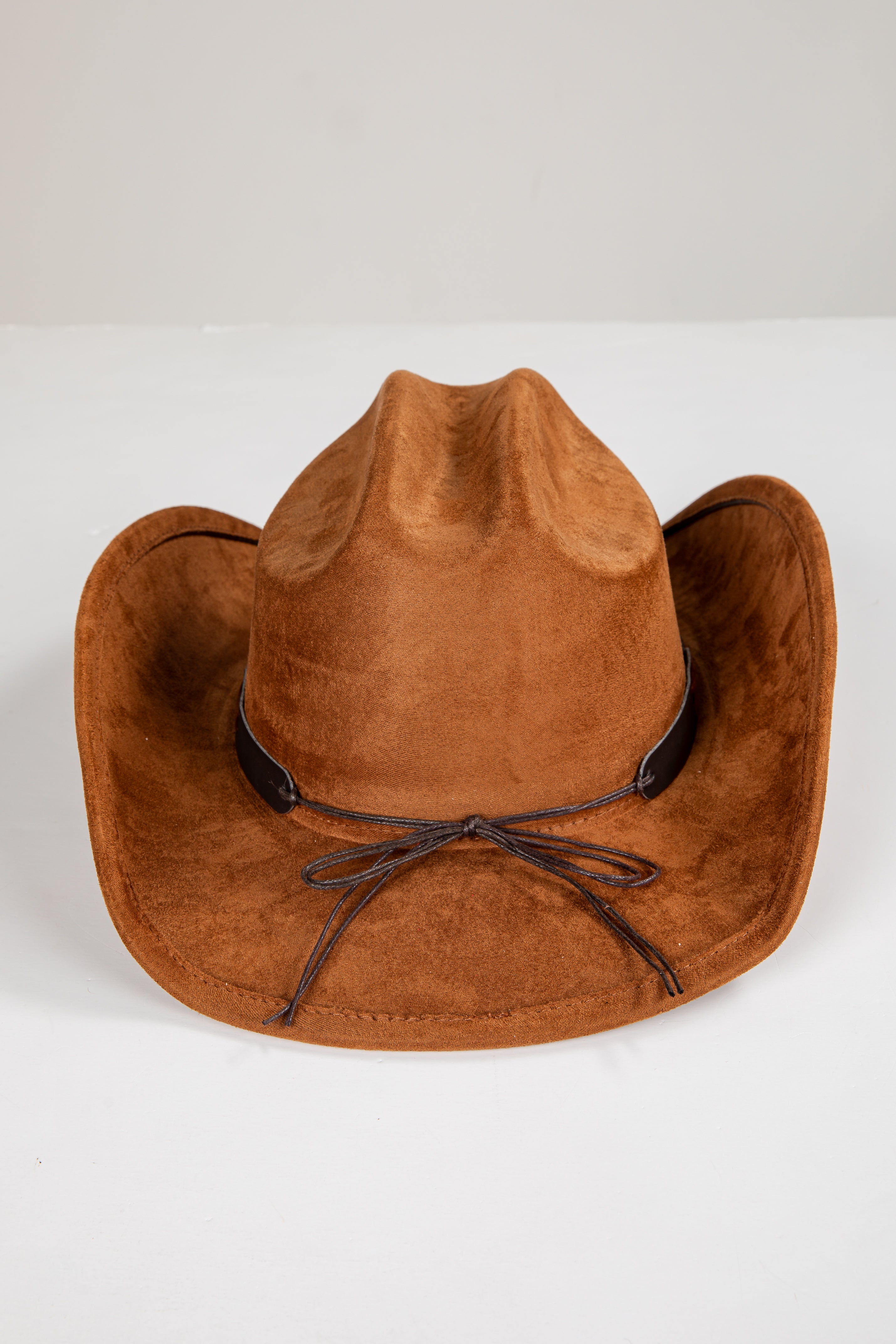 Brown cowboy hat with a black band on a white background