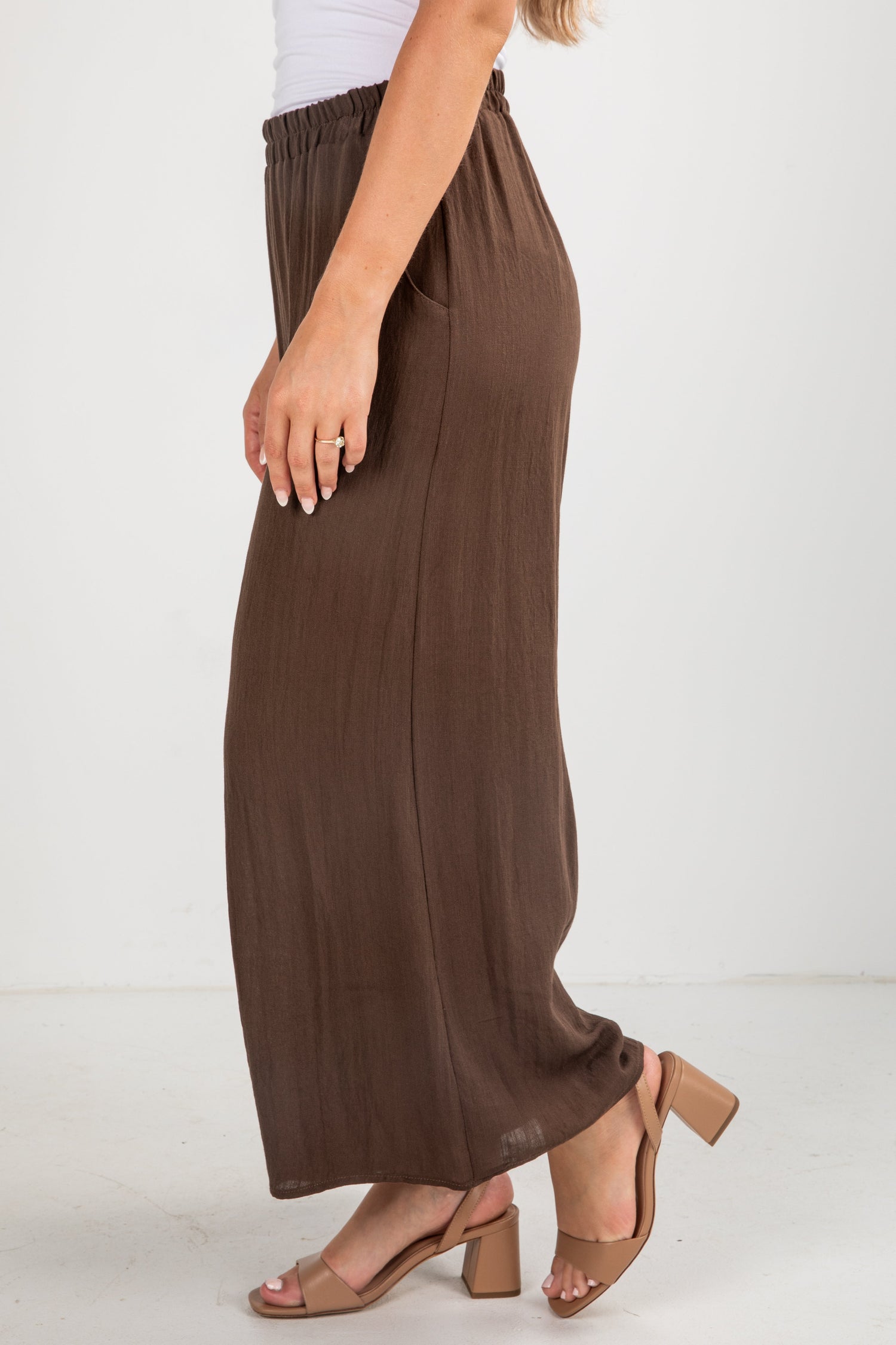 Brown wide-leg pants worn by a person on a white background