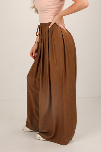 Brown wide-leg pants worn by a person on a plain background