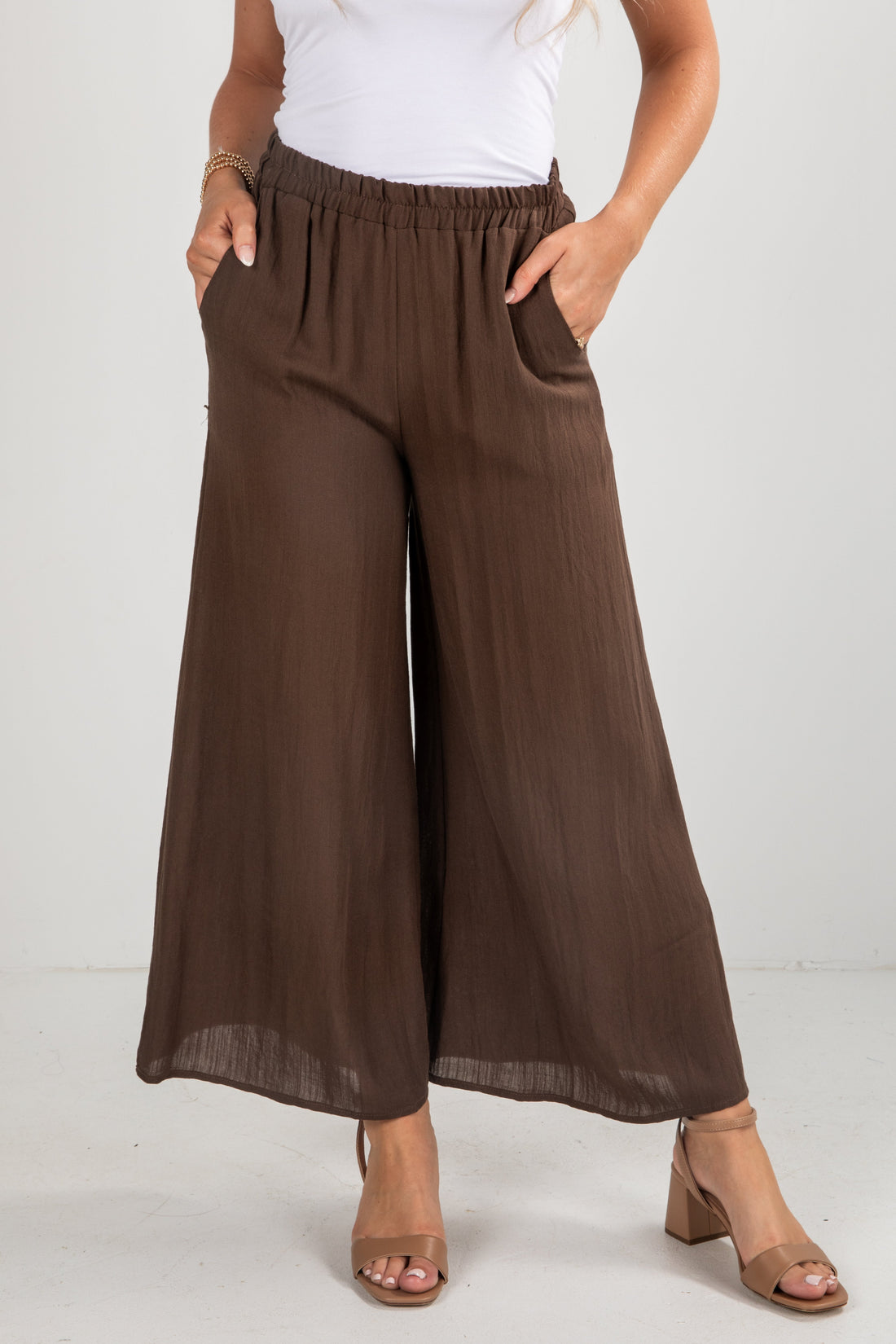 Brown wide-leg pants worn by a person on a white background