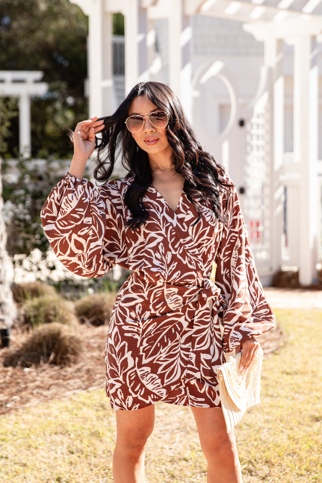 Woman wearing a brown and white patterned dress outdoors.