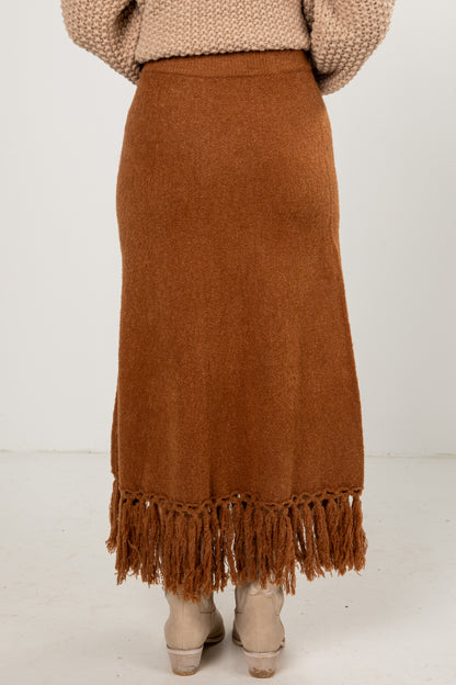 Brown fringed skirt worn by a person on a white background