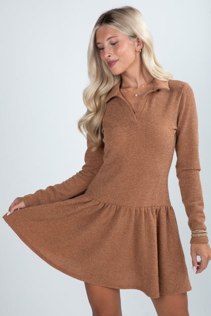 Woman wearing a brown dress with long sleeves on a white background