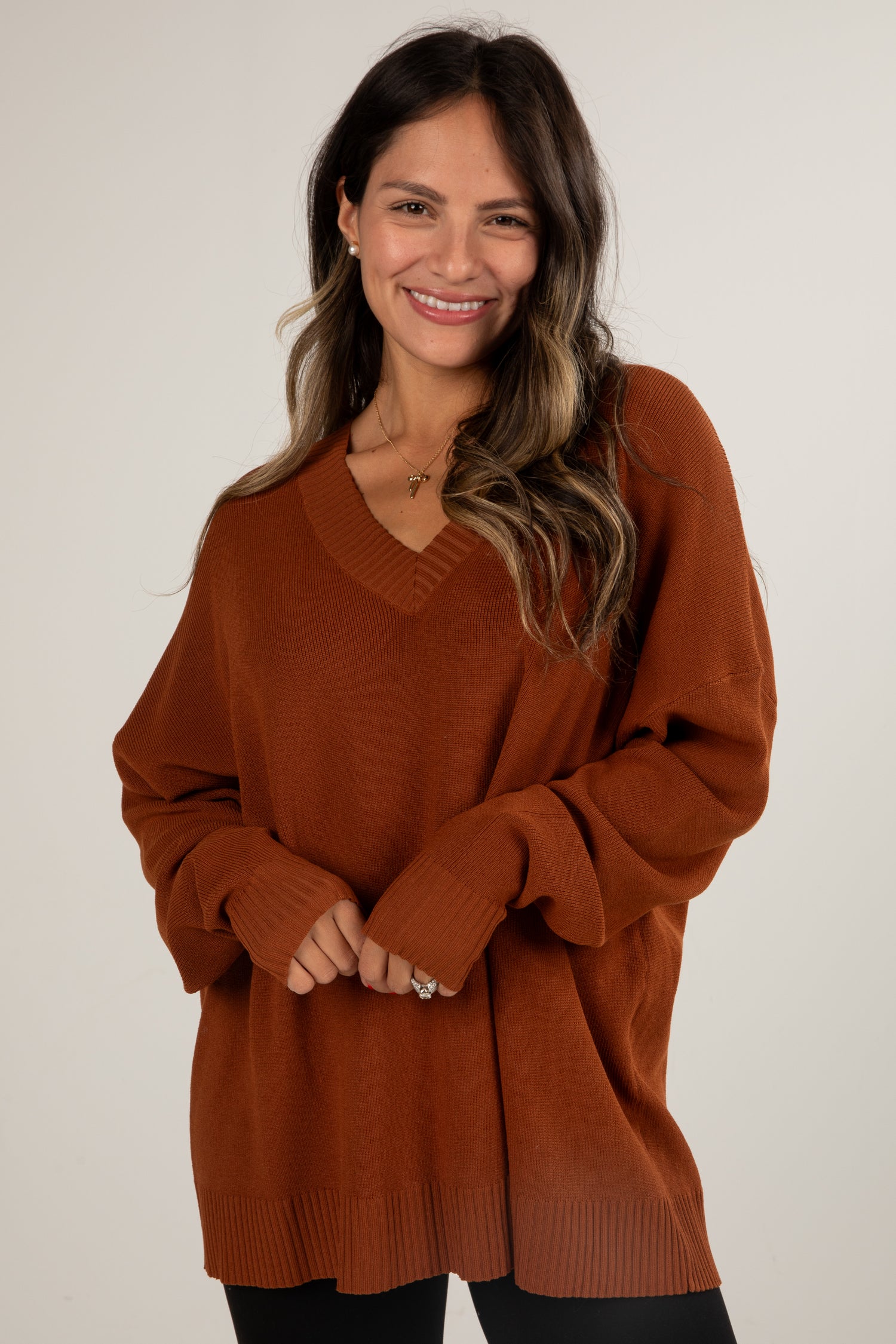 Woman wearing a brown sweater against a white background