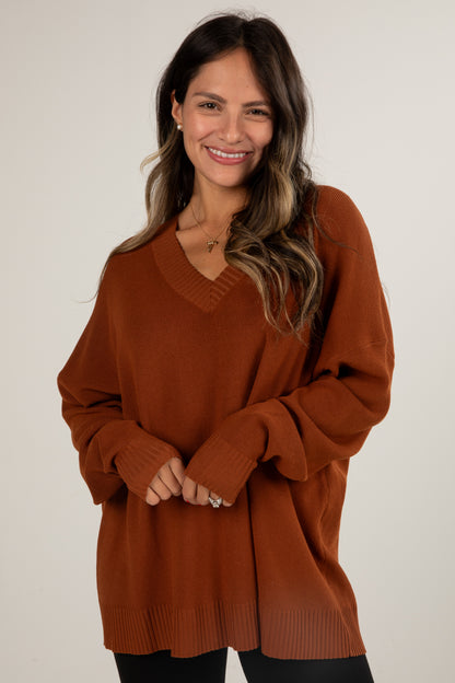 Woman wearing a brown sweater against a white background