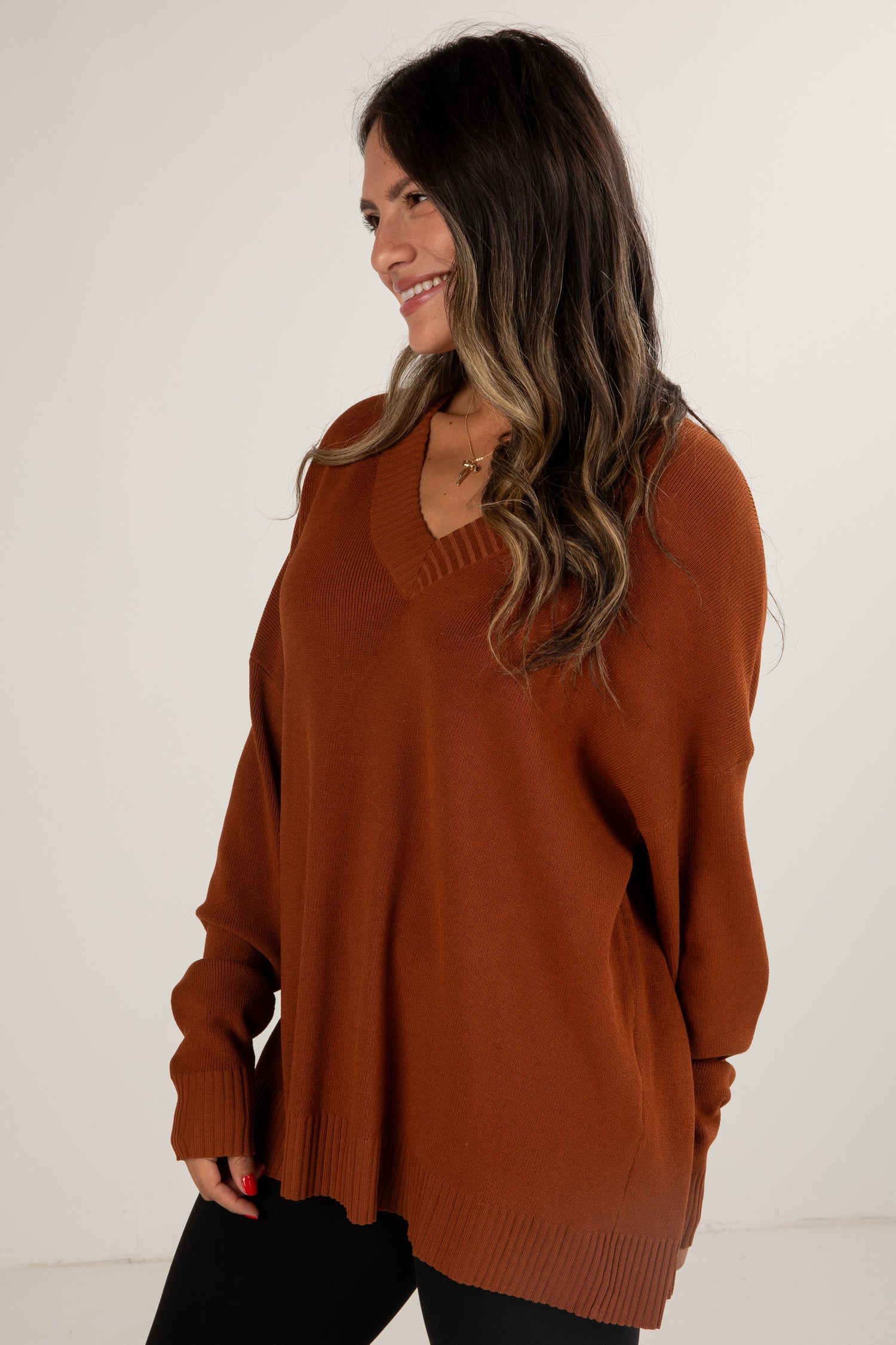 Woman wearing a brown sweater against a white background