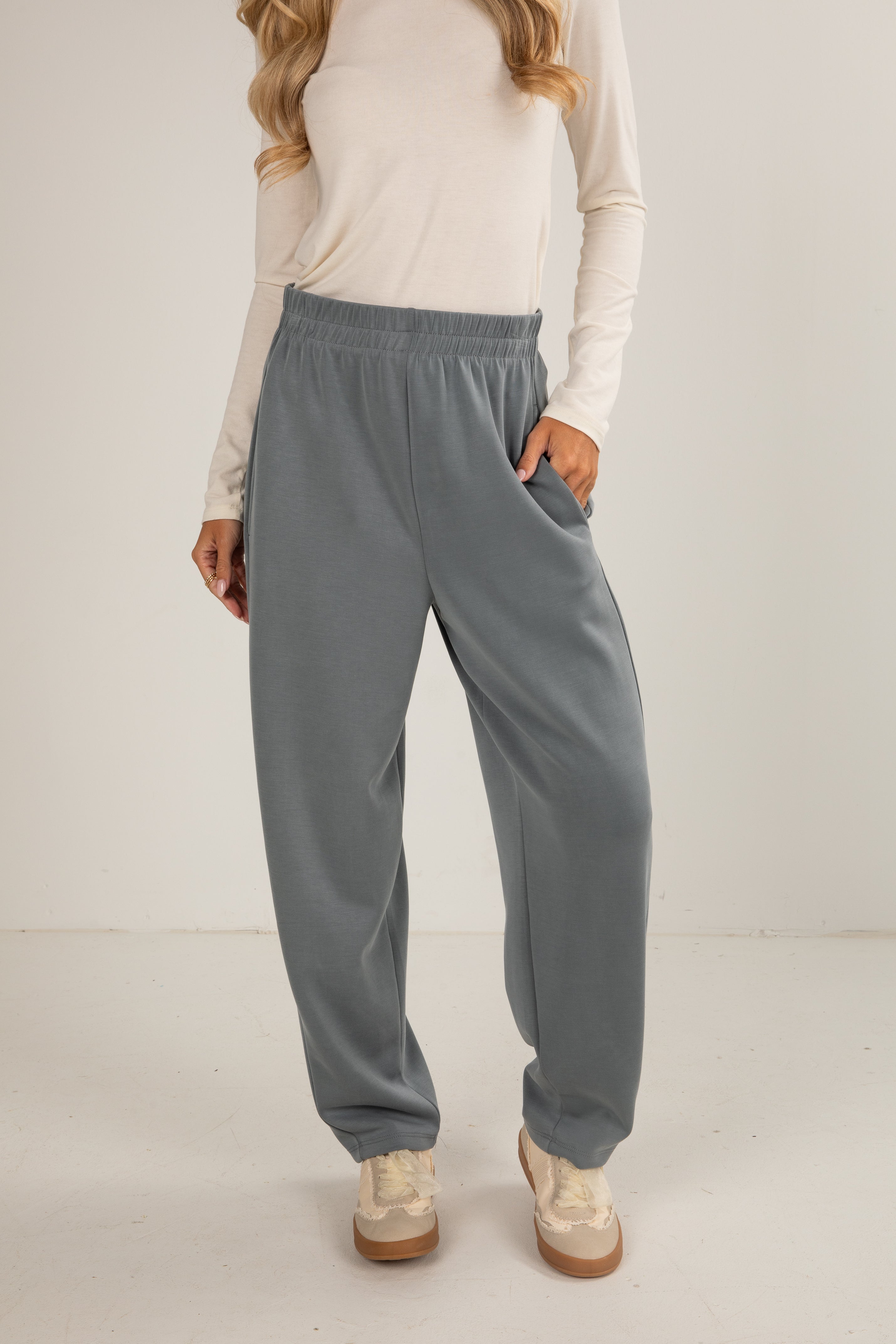 Person wearing light gray sweatpants on a white background