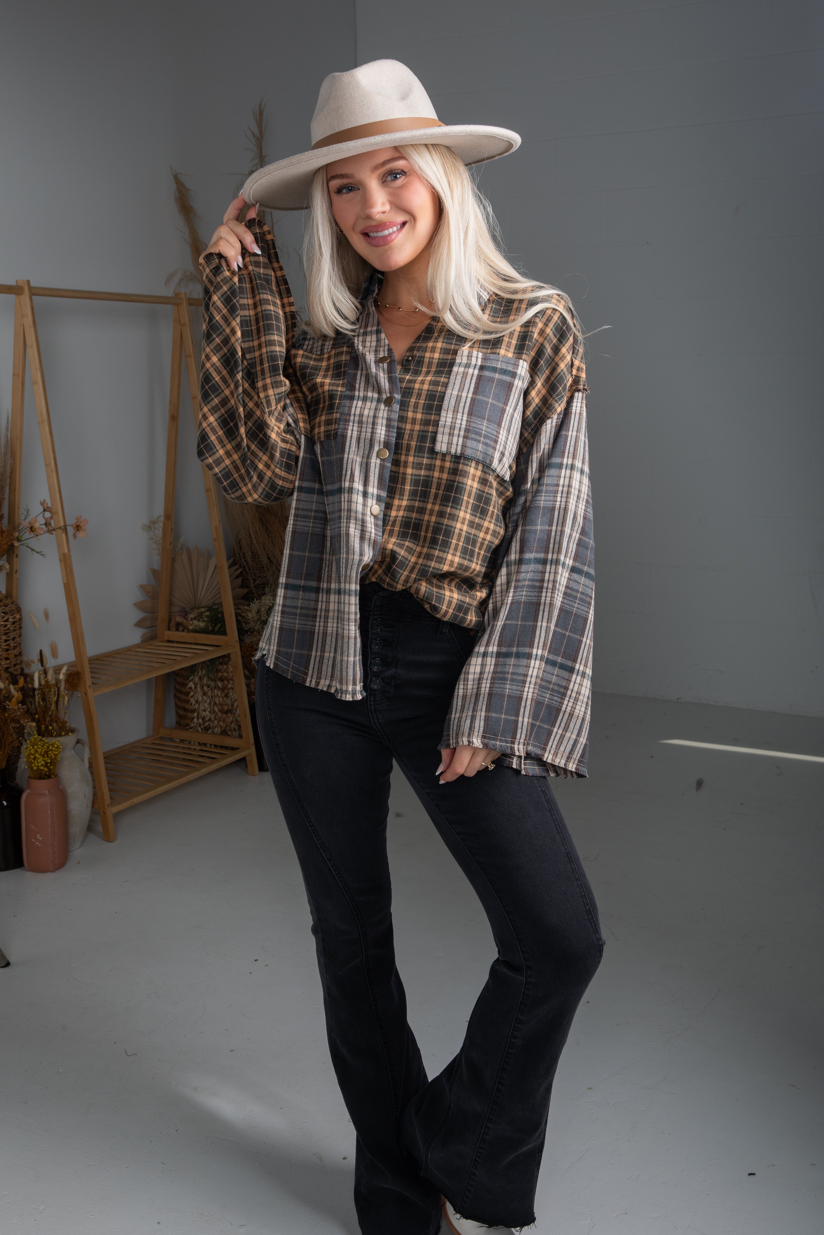 Woman wearing a plaid shirt and hat in a studio setting