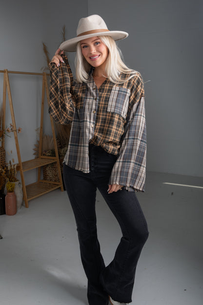 Woman wearing a plaid shirt and hat in a studio setting