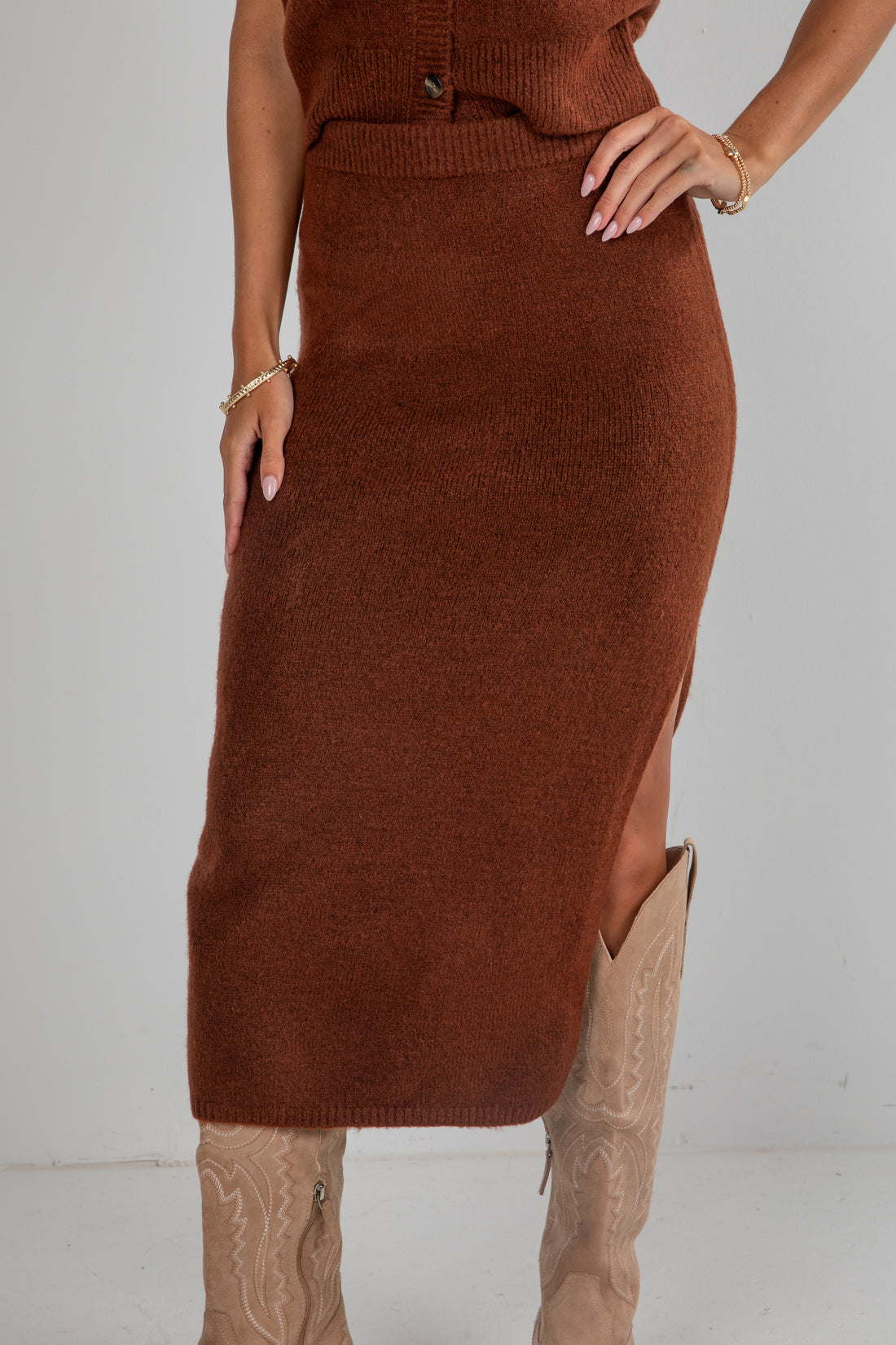 Brown knit dress with a slit on a plain background
