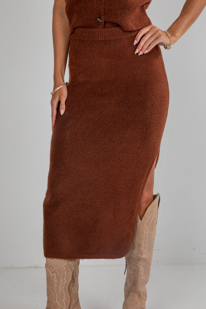 Brown knit dress with a slit on a plain background
